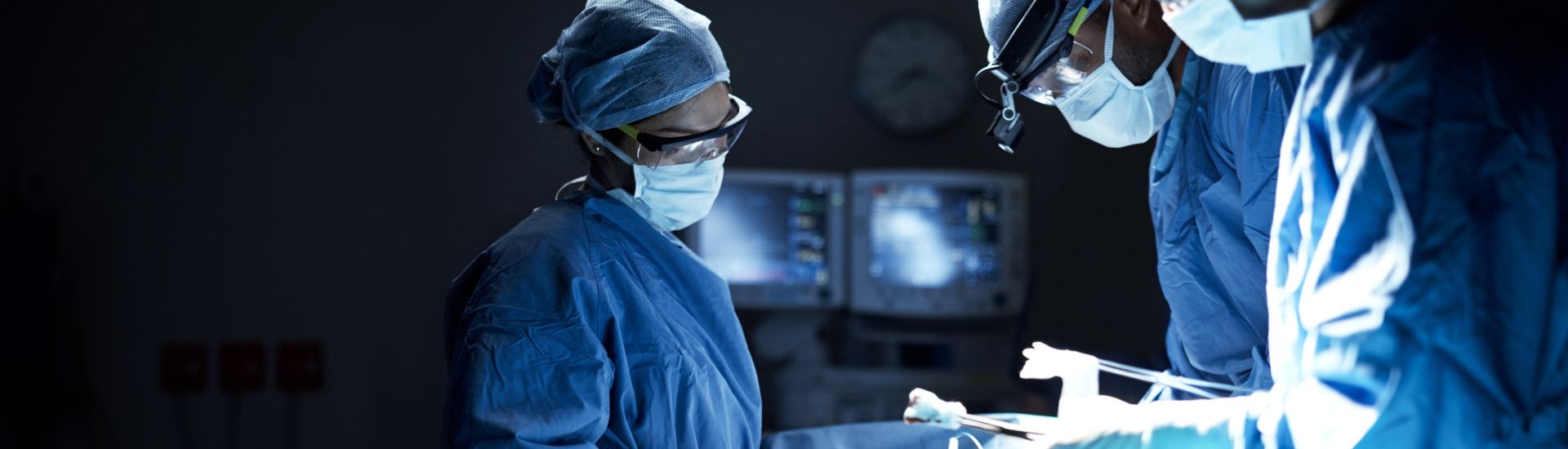 three surgeons in the middle of a surgery in the operating room